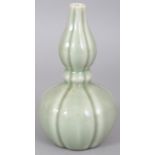 A CHINESE CELADON DOUBLE GOURD PORCELAIN VASE, of fluted hexafoil section, the base with a