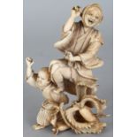 A JAPANESE MEIJI PERIOD IVORY OKIMONO OF A FARMER & HIS SON, unsigned, leaping before two giant