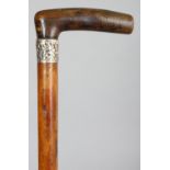 ANOTHER RHINOCEROS HORN HANDLED WOOD WALKING STICK, with a hallmarked and embossed silver collar,