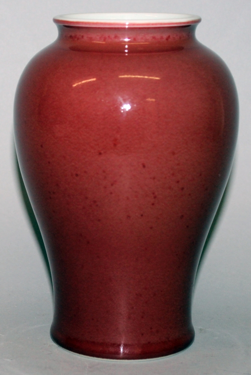 A CHINESE SANG-DE-BOEUF PORCELAIN VASE, the glaze slightly mottled, the base unglazed, 7.5in high.