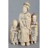 A JAPANESE MEIJI PERIOD IVORY OKIMONO OF A FAMILY GROUP, unsigned, centred by a standing lady on