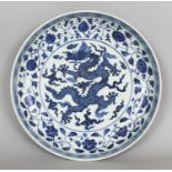 A LARGE CHINESE YUAN STYLE BLUE & WHITE PORCELAIN DRAGON DISH, the rim with an extended six-