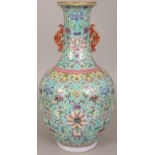 A CHINESE FAMILLE ROSE TURQUOISE GROUND PORCELAIN VASE, decorated with formal arrangements of