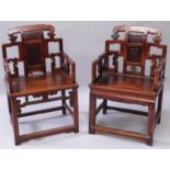 A PAIR OF CHINESE CARVED HARDWOOD CHAIRS, each back rest carved with a figural and with an archaic