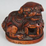 A JAPANESE MEIJI PERIOD CARVED WOOD NETSUKE OF A SHI-SHI, unsigned, with a brocaded ball, 1.75in