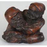 A JAPANESE MEIJI PERIOD WOOD NETSUKE OF A MASK MAKER, unsigned, the seated man examining a mask, 1.