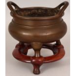 AN 18TH/19TH CENTURY CHINESE BRONZE CENSER, weighing 1.76Kg, together with a fitted wood stand,