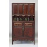 A CHINESE HARDWOOD CABINET, with two doors opening above an unusual mirrored gallery fitted with