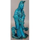 AN EARLY 20TH CENTURY CHINESE TURQUOISE GLAZED FIGURE OF GUANYIN, standing in flowing robes, the