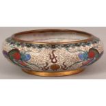 AN EARLY 20TH CENTURY CHINESE WHITE GROUND CLOISONNE SHALLOW BOWL, decorated with dragons pursuing
