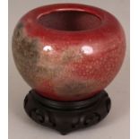 A CHINESE PEACH BLOOM PORCELAIN WATER POT, together with a fitted wood stand, the glaze with grey