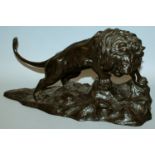 A GOOD QUALITY SIGNED JAPANESE MEIJI PERIOD BRONZE MODEL OF A LION, prowling on rockwork, the top of
