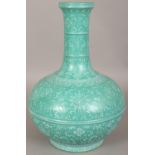 AN UNUSUAL CHINESE LIME GREEN GROUND PORCELAIN BOTTLE VASE, decorated in white slip with Shou