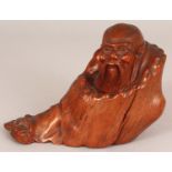 A GOOD QUALITY 19TH CARVED ROOTWOOD FIGURE OF A RECLINING SAGE, wrapped in a well grained cloak, 6.