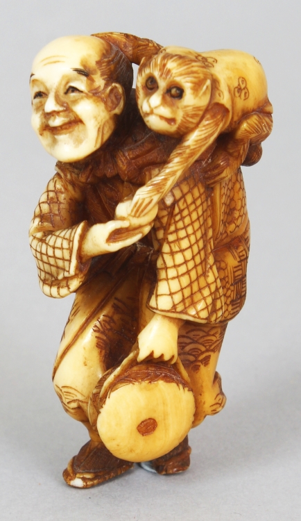 A GOOD QUALITY JAPANESE MEIJI PERIOD STAINED IVORY NETSUKE OF A MONKEY PERFORMER, unsigned, the