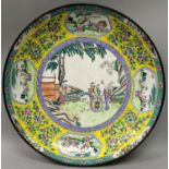 A LARGE 19TH CENTURY CHINESE CANTON ENAMEL DISH, decorated to its centre with a garden figural scene