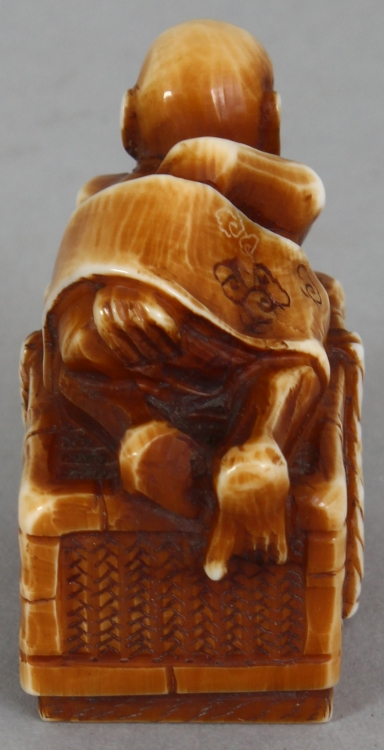 A SIGNED JAPANESE MEIJI PERIOD STAINED IVORY NETSUKE OF A DEMON, lying astride a rectangular reed - Image 4 of 9