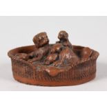 A SMALL BRONZE OF A DOG with pups in a basket. 3ins long.