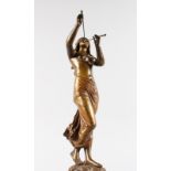 EDOUARD DROUT (1859-1945) FRENCH A BRONZE OF A NYMPH playing pipes, standing on a circular marble