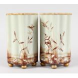 A PAIR OF VICTORIAN SQUARE SHAPED MILK GLASS VASES painted with storks, supported on four gilt
