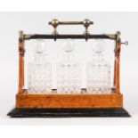 A THREE BOTTLE CUT GLASS TANTALUS in a mahogany carrying case.