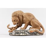 AFTER BARYE. A POTTERY LION with a serpent. 8ins long.