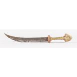 A TURKISH DAGGER with brass and steel decorated handle, curving blade and leather sheath. 17.5ins