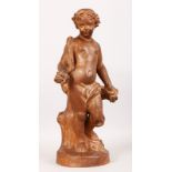 AFTER THE ANTIQUE A SUPERB TERRACOTTA STANDING CUPID, clad in a robe and standing on a circular