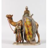 AN AUSTRIAN PAINTED METAL ARAB GROUP LIGHTER, two men with a camel. 7ins high.