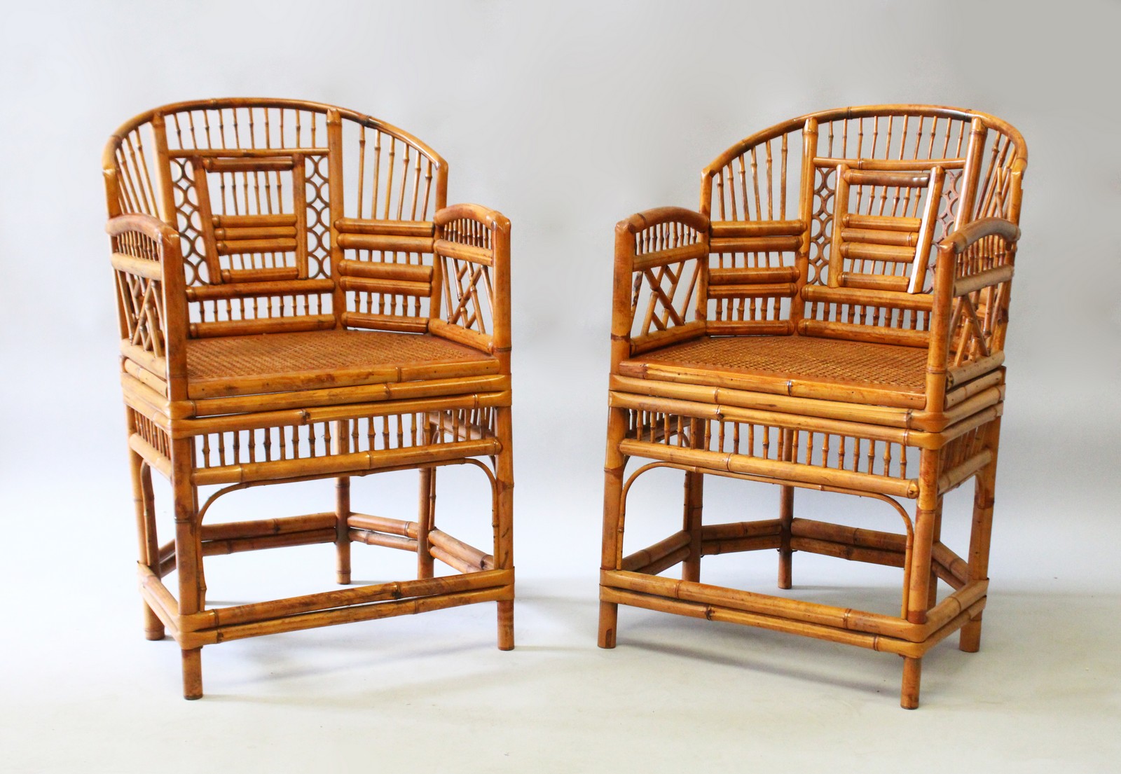 A GOOD PAIR OF BAMBOO ARMCHAIRS with canework seats.