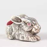 A LARGE SILVER RABBIT PIN CUSHION with ruby eyes.