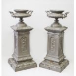 A SUPERB PAIR OF FRENCH PAINTED CAST IRON CIRCULAR TWO HANDLED URNS ON STANDS by ALDRED CORNEAU A.