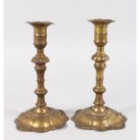 A PAIR OF EARLY PETAL BASE BRASS CANDLESTICKS. 8ins high. One Base Damaged.
