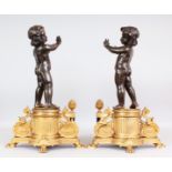 A SUPERB PAIR OF LOUIS XVI BRONZE AND ORMOLU CHENETS, with two bronzes of children standing on