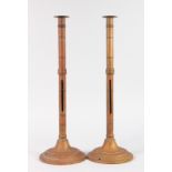 A TALL PAIR OF BRASS CANDLESTICKS on circular bases. 20ins high.