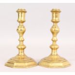 A PAIR OF EARLY BRASS CANDLESTICKS on octagonal bases. 7.5ins high.