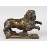 A GRAND TOUR BRONZE LION on a rectangular base. 9ins long.