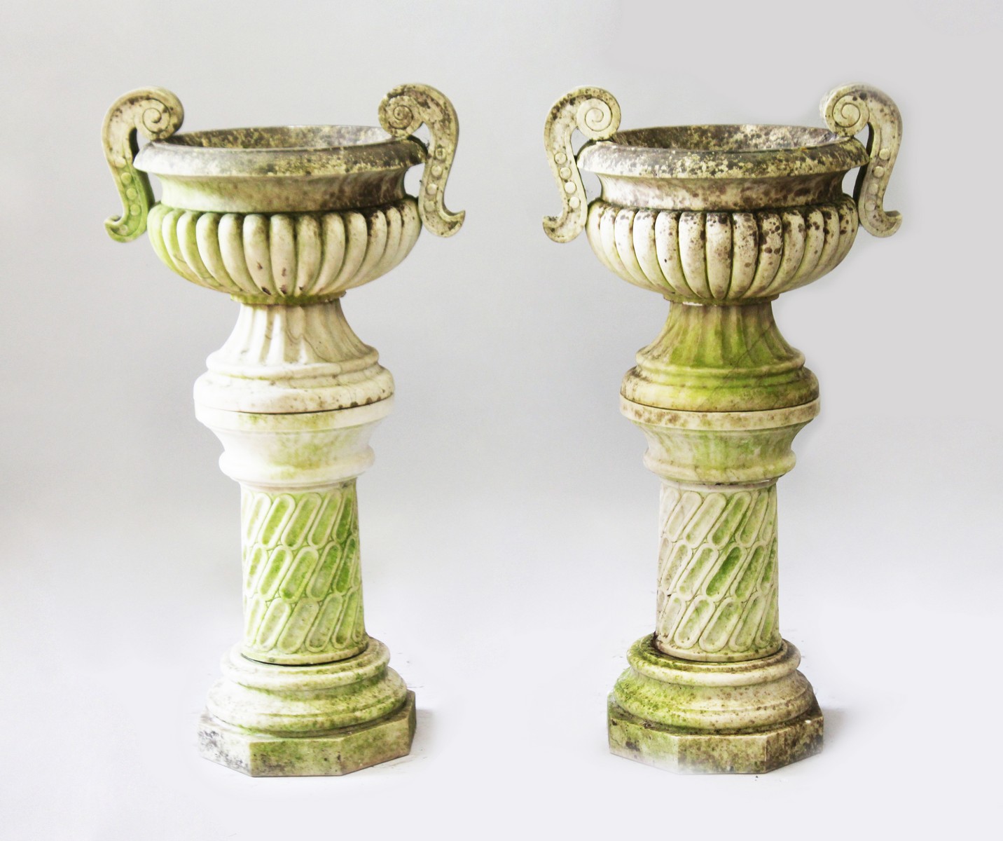 A VERY GOOD PAIR OF CARVED WHITE MARBLE CIRCULAR TWO HANDLED URNS ON STANDS, in the Chinese