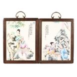 A PAIR OF CHINESE PORCELAIN PLAQUES, with figures and calligraphy in wooden frame. 13ins x 9.5ins.