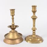 AN EARLY BRASS PETAL BASE CANDLESTICK, 9ins high, and another with stepped circular base, 8.5ins