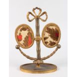 A FRENCH ORMOLU DOUBLE PHOTOGRAPH STAND on an oval base. 11ins high.