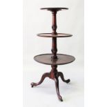 A GEORGIAN MAHOGANY THREE TIER CIRCULAR DUMB WAITER with central turned column ending in a tripod