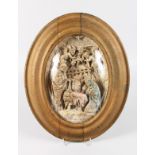 A LAVA STONE OVAL "NATIVITY". 11ins x 7.5ins, in a gilt oval frame.