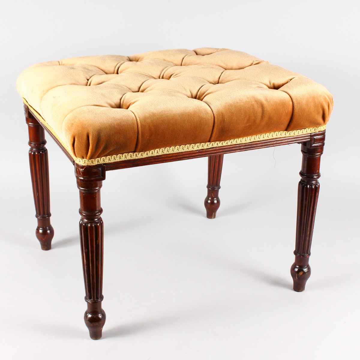 A GOOD MAHOGANY STOOL with padded seat on turned and fluted legs.