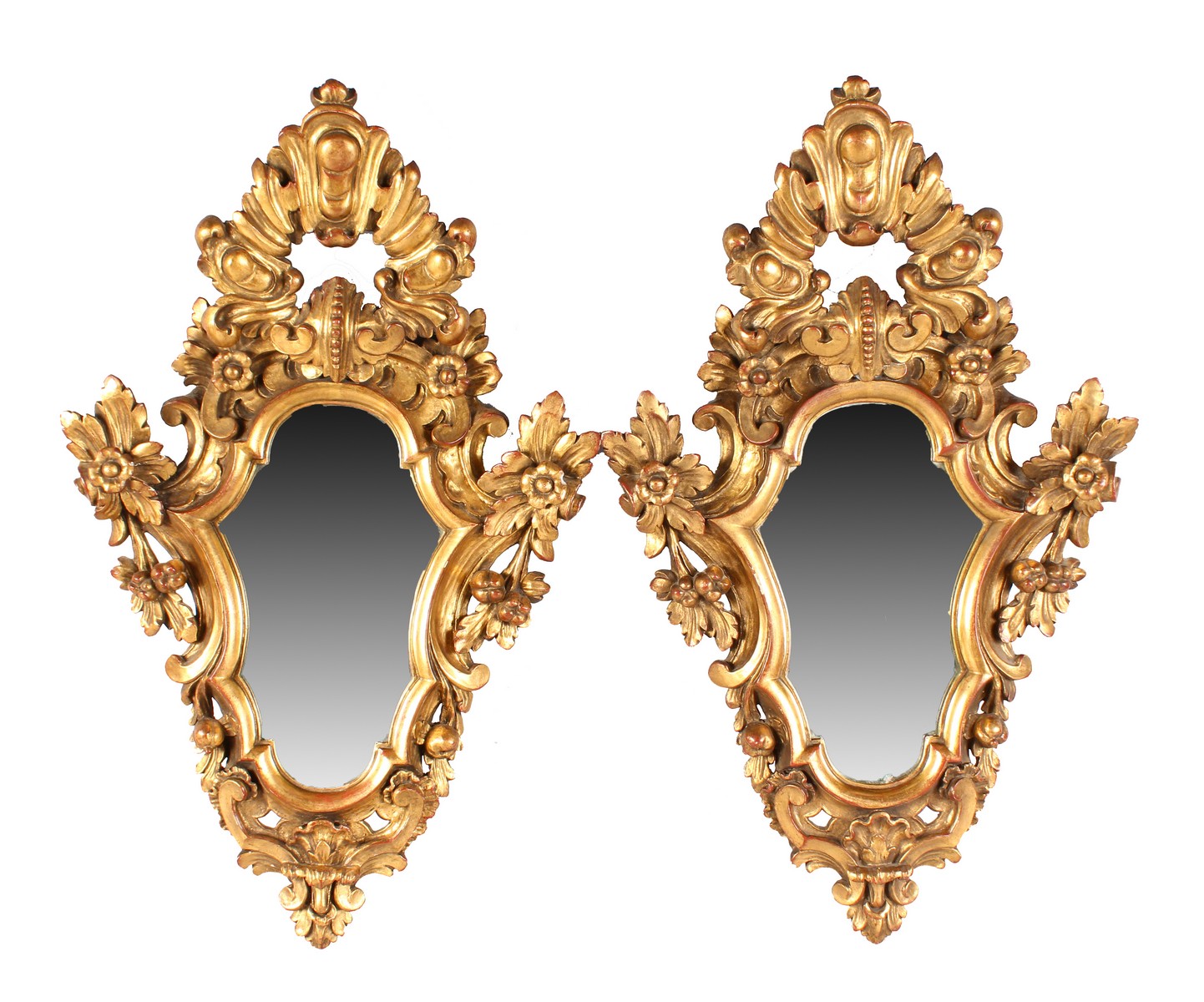 A PAIR OF ITALIAN SHAPED AND CARVED GILTWOOD MIRRORS with acanthus and flower heads. 2ft 5ins long.