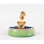 A DOULTON LAMBETH STONEWARE ASHTRAY as a pixie sitting overlooking a blue pool. 4ins diameter. No.