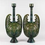 A LARGE PAIR OF GREEN ISLAMIC VASES decorated with dolphins, leaves and flowers. 24ins high.