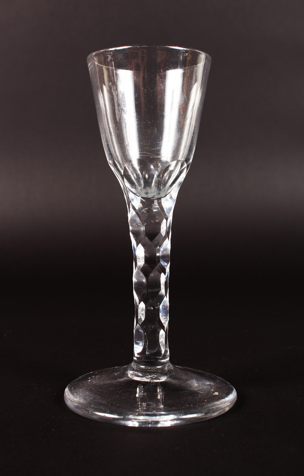 A WINE GLASS WITH FACET CUT STEM. 6ins high.