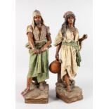 A LARGE PAIR OF AUSTRIAN TERRACOTTA FIGURES OF A TURKISH MAN carrying a sword and A YOUNG GIRL