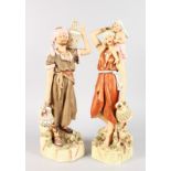 A LARGE PAIR OF ROYAL DUX FIGURES OF AN ARAB MAN AND WOMAN, the man carrying two water pitchers, the